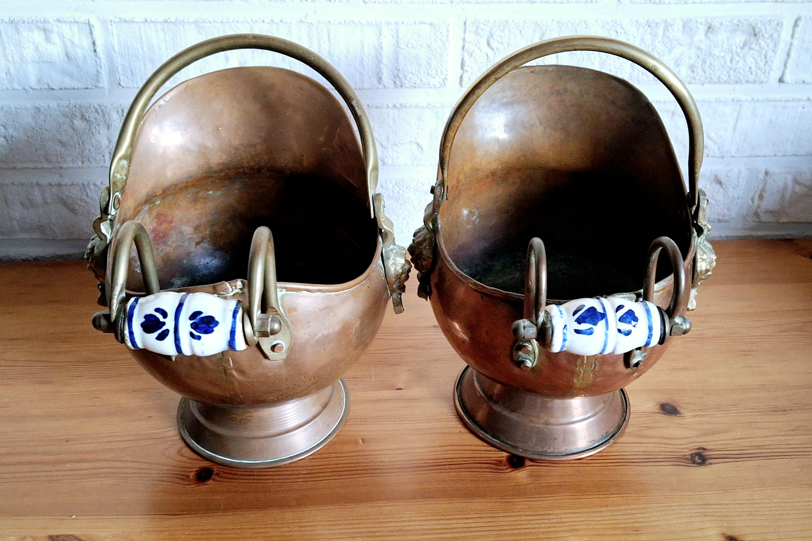 Vintage copper coal scuttle bucket pair with ceramic Delft handles and brass lion head