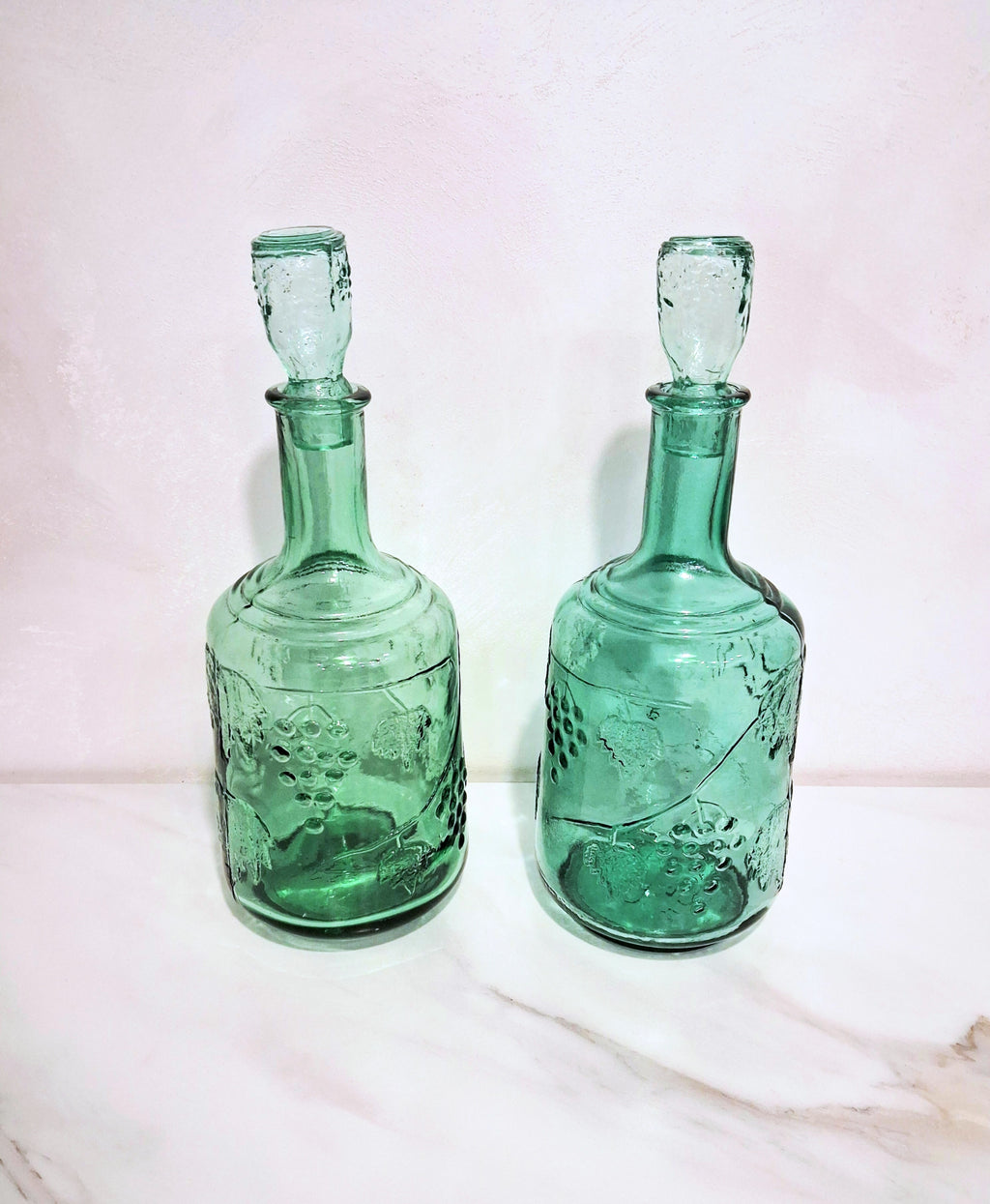 Pair of green glass Decanters with stoppers, Embossed grape motif