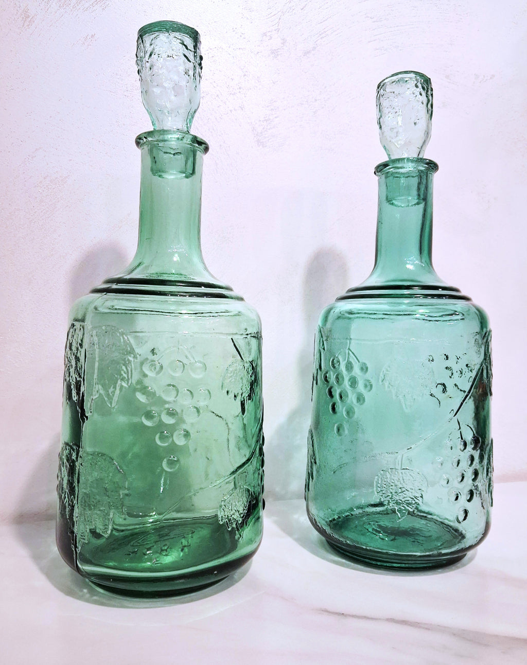 Pair of green glass Decanters with stoppers, Embossed grape motif