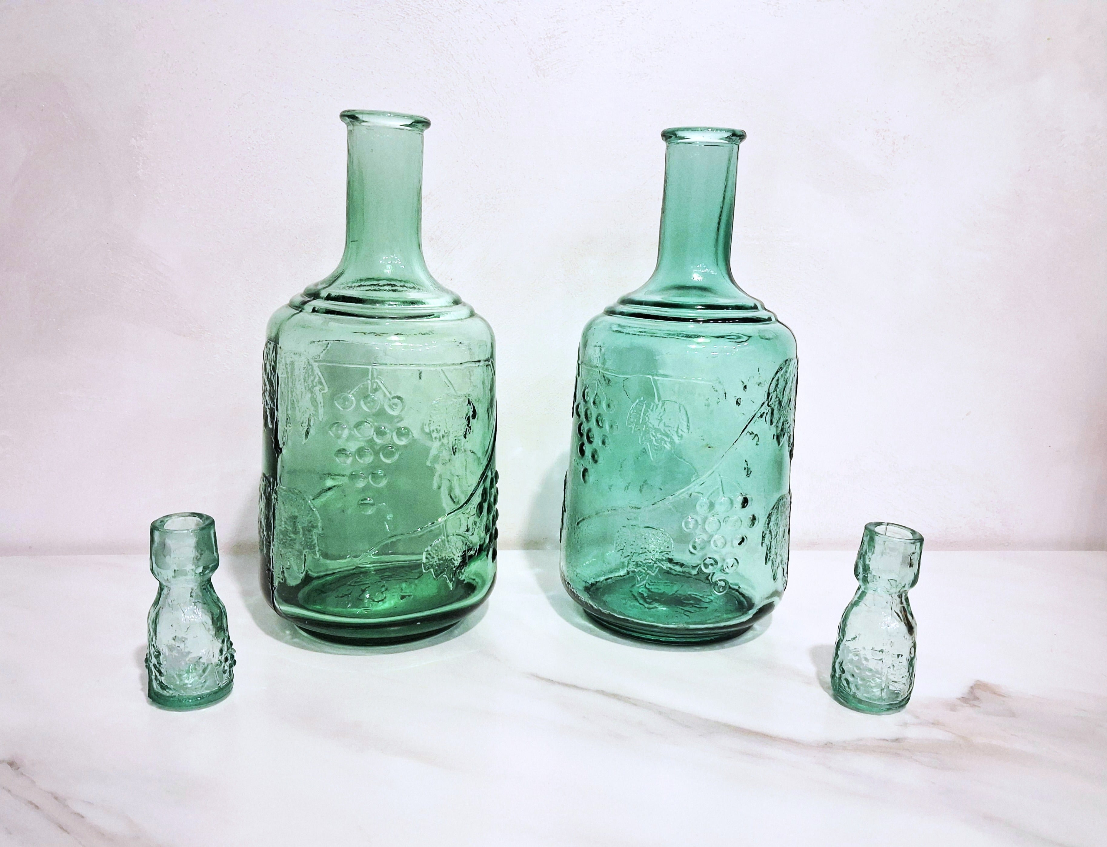 Pair of green glass Decanters with stoppers, Embossed grape motif