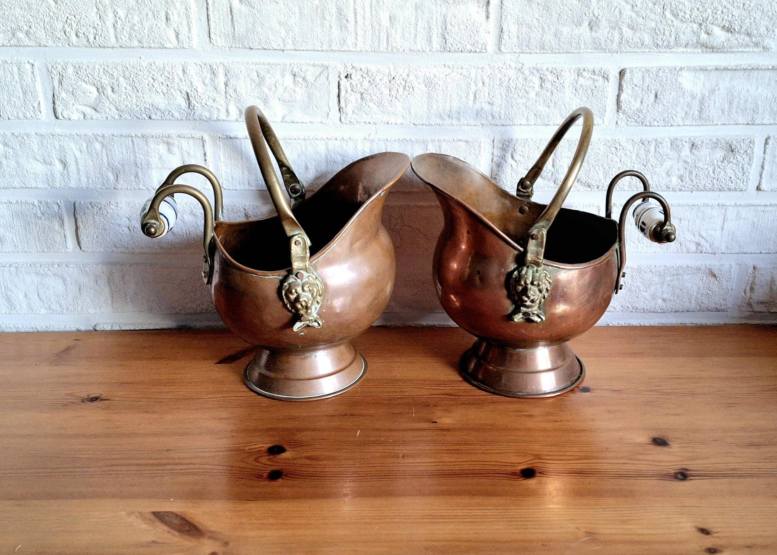 Vintage copper coal scuttle bucket pair with ceramic Delft handles and brass lion head
